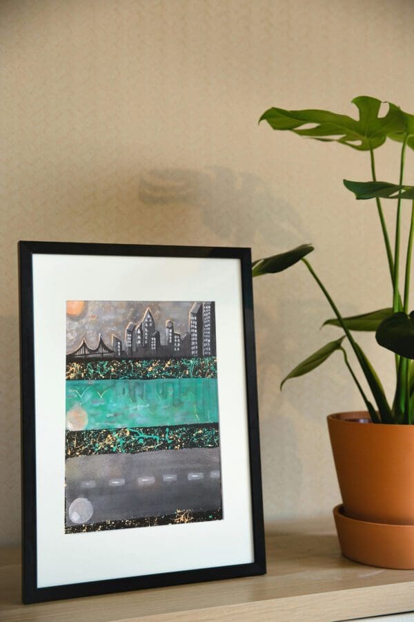 Framed abstract cityscape painting.